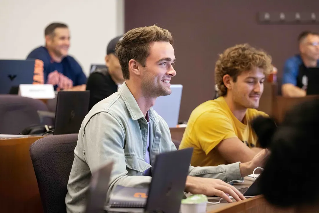 Student sits and smiles in class.